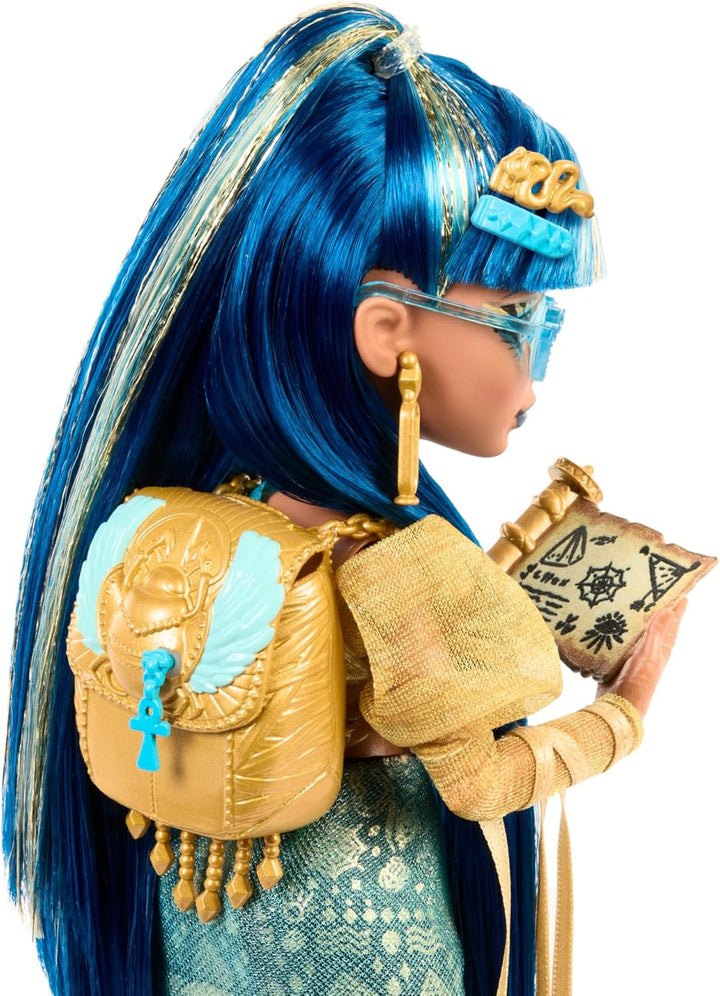 Păpușă Monster High Cleo De Nile în bluză aurie și fustă stratificată, include animal de companie Cobra Hissette și accesorii precum rucsac, gustare și rolă de hârtie, HXH74