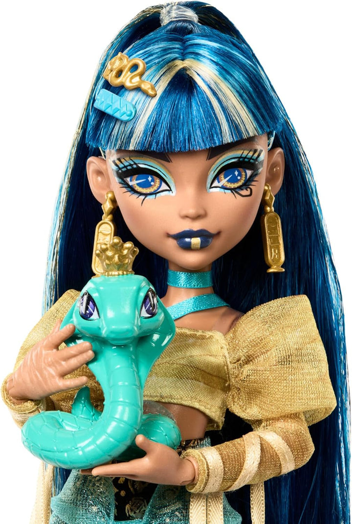 Păpușă Monster High Cleo De Nile în bluză aurie și fustă stratificată, include animal de companie Cobra Hissette și accesorii precum rucsac, gustare și rolă de hârtie, HXH74