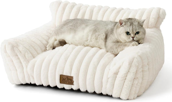 Canapea COZY KISS pentru pisici mici și mari, pat confortabil pentru pisici cu margini de susținere și bază antiderapantă, lavabil, blană artificială moale, ideal pentru sufragerie sau dormitor (crem, 65 x 44 x 30)